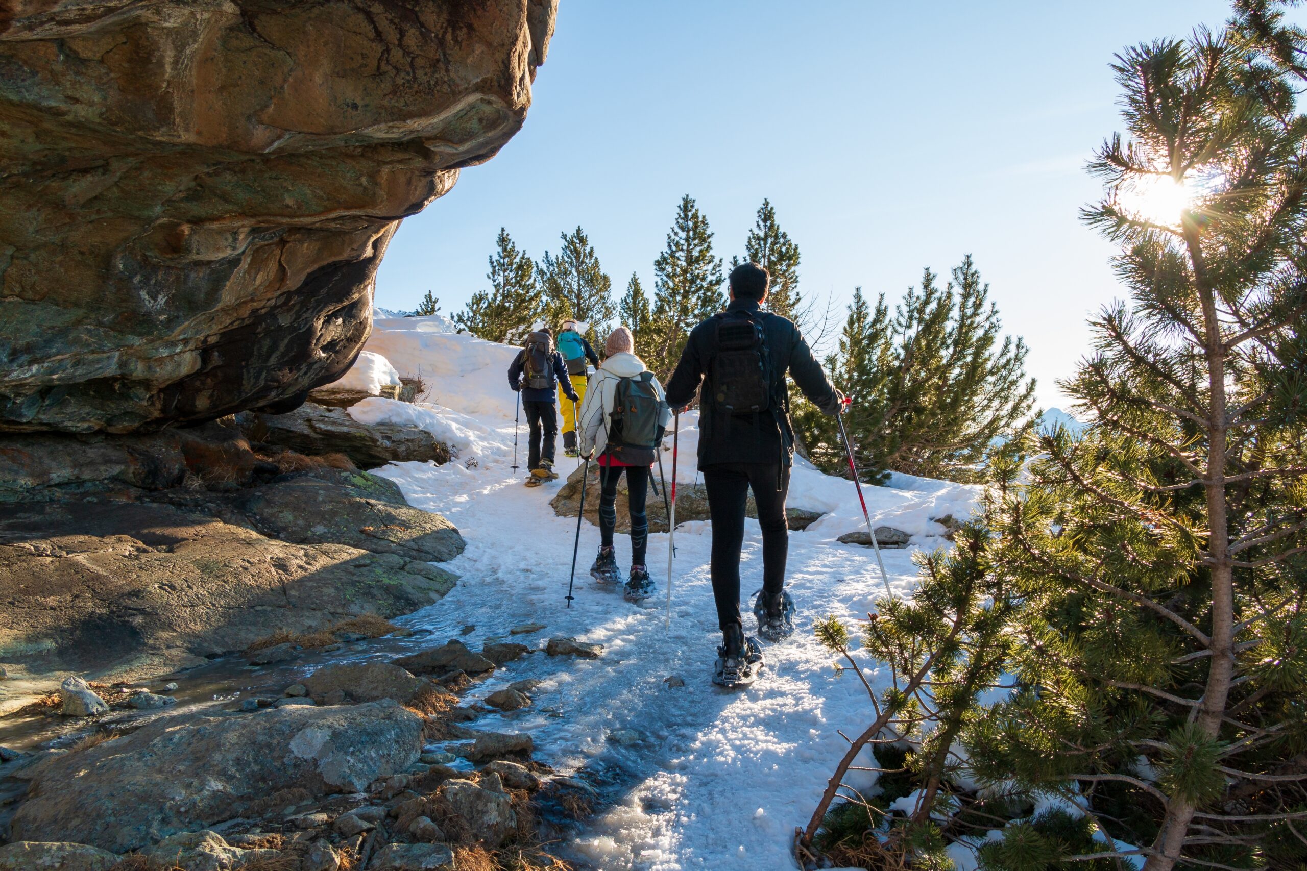 Group,Of,Hikers,Crosses,A,Rocky,Passage,On,Snowshoes